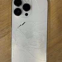 White iPhone Pro with severely shattered back glass